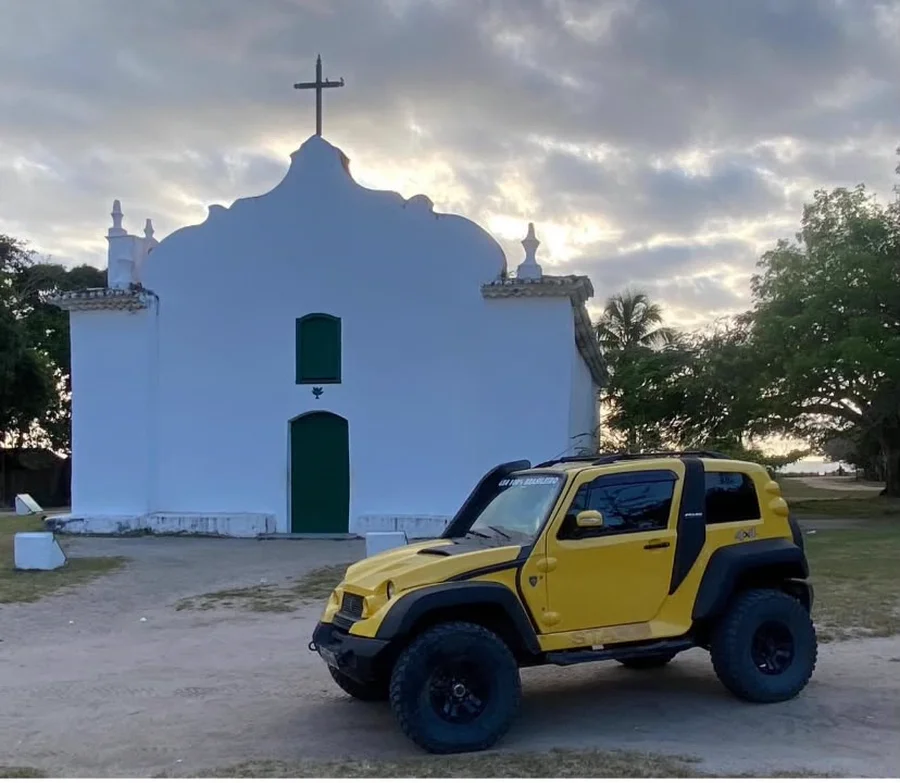 Jipe 4x4 amarelo da Trilha e Mar em frente à igreja do Quadrado, em Trancoso